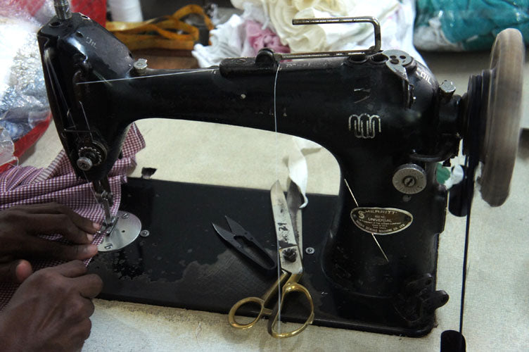 Tailor's machine with scissors and a pair of hands working